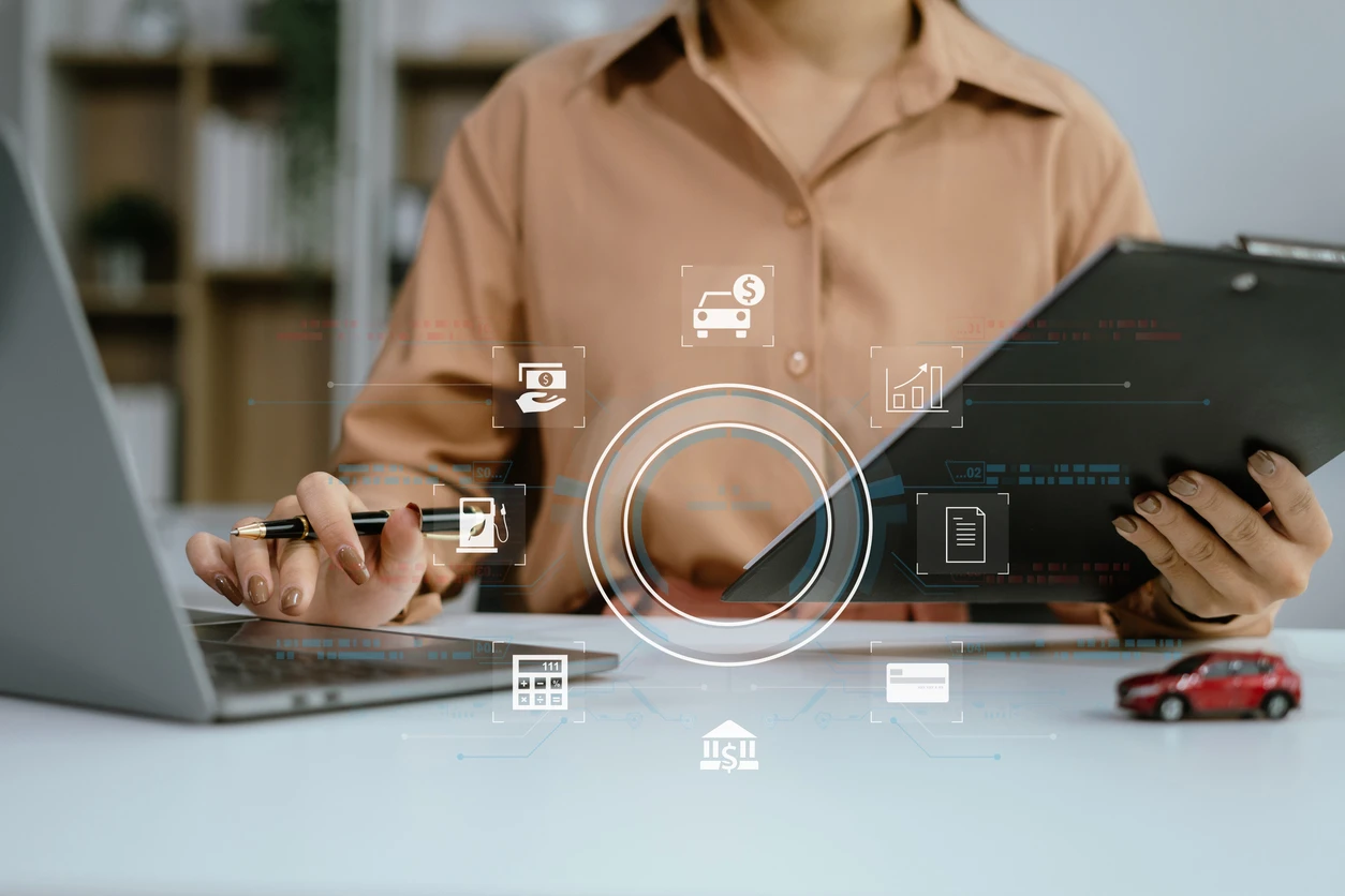 Pessoa realizando análise financeira com laptop, tablet e gráficos digitais relacionados a serviços financeiros e investimentos.